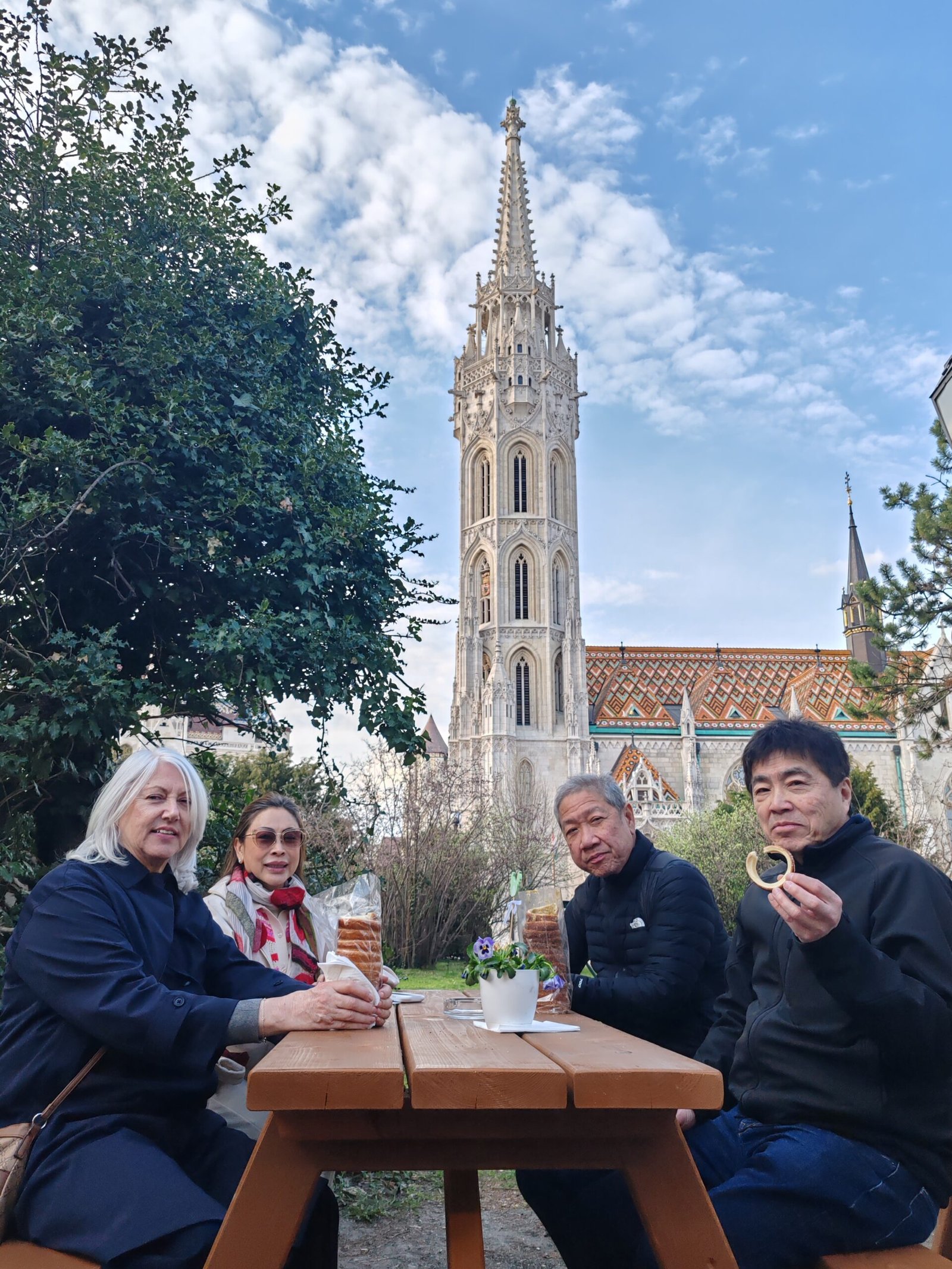 Guests enjoying traditional Hungarian chimney cake during a private Budapest food tour at Matthias Church in the Buda Castle District.